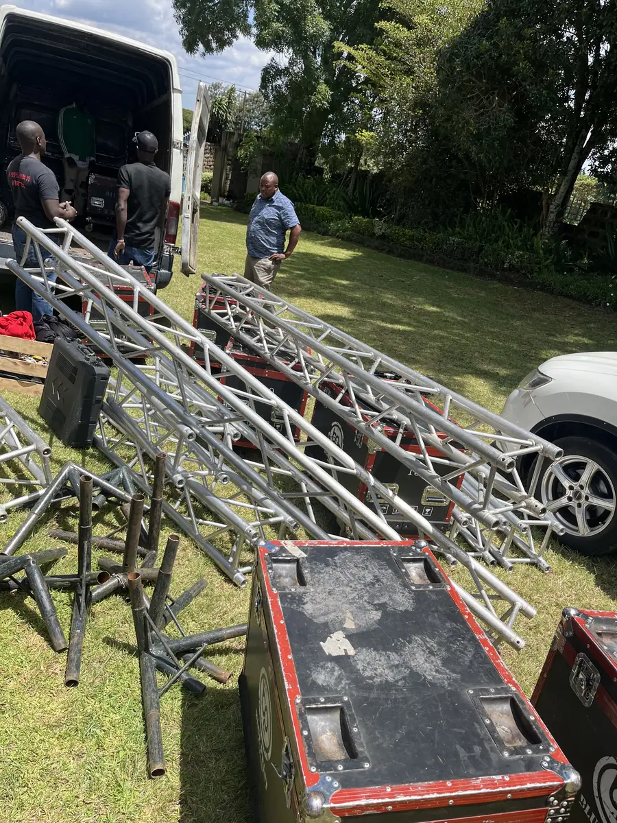 Crew unloading truss and equipment cases on site before an event build