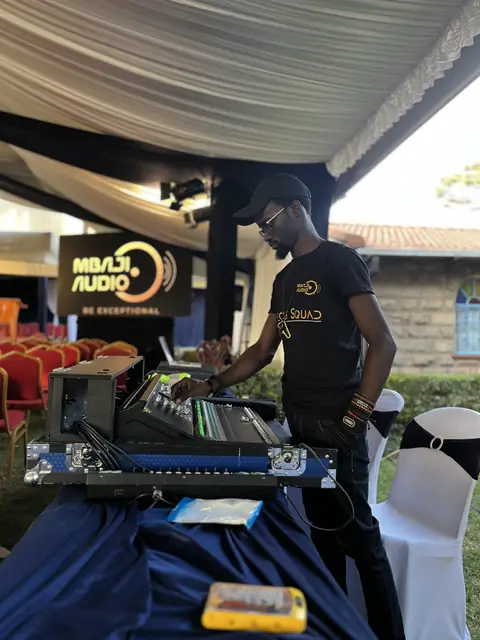 Mbaji Audio engineer at a mixing console inside an event tent