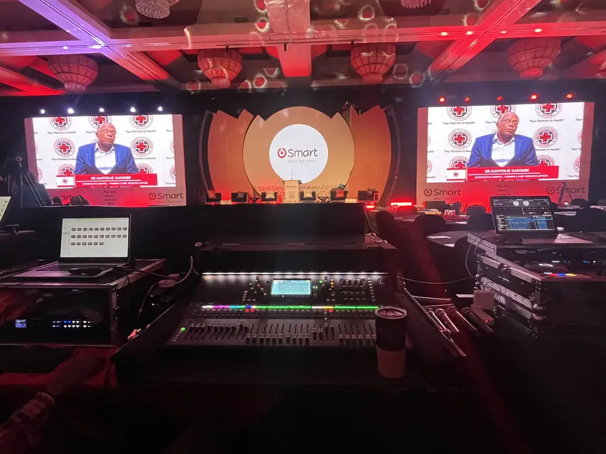 Mixing console in front of LED screens at the SMART Summit