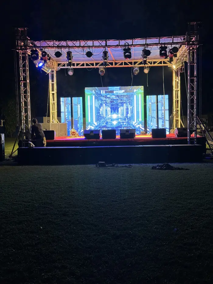 Outdoor stage at night with truss, lighting rig and LED screens for the Legends Cup
